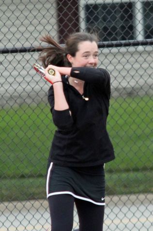 Carney is all smiles as she takes a swing to earn the point.