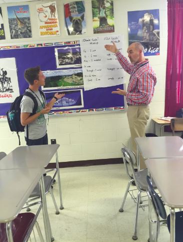 In his 22 years at West, Hawkins has spread his optimism to students. Here, he explains a concept to a Spanish 4 student. Photo by Kelsey Warren. 