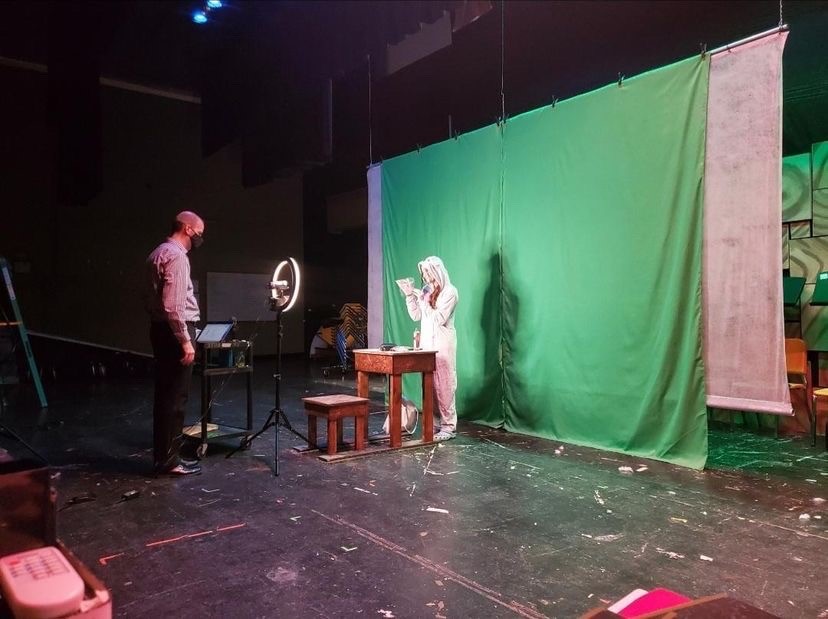 Mr. Deboer films a performer in front of the green screen. 